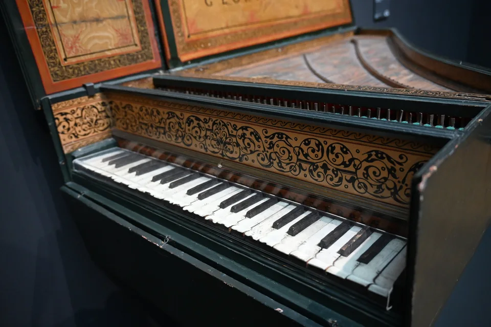 O teclado ornamentado e a tampa pintada de um instrumento histórico