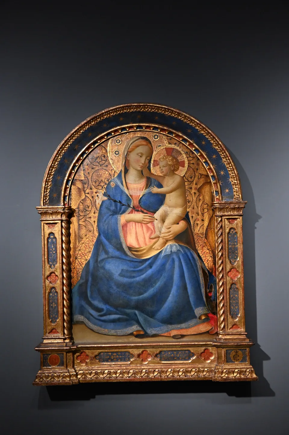 Uma pintura religiosa dourada em uma moldura em arco