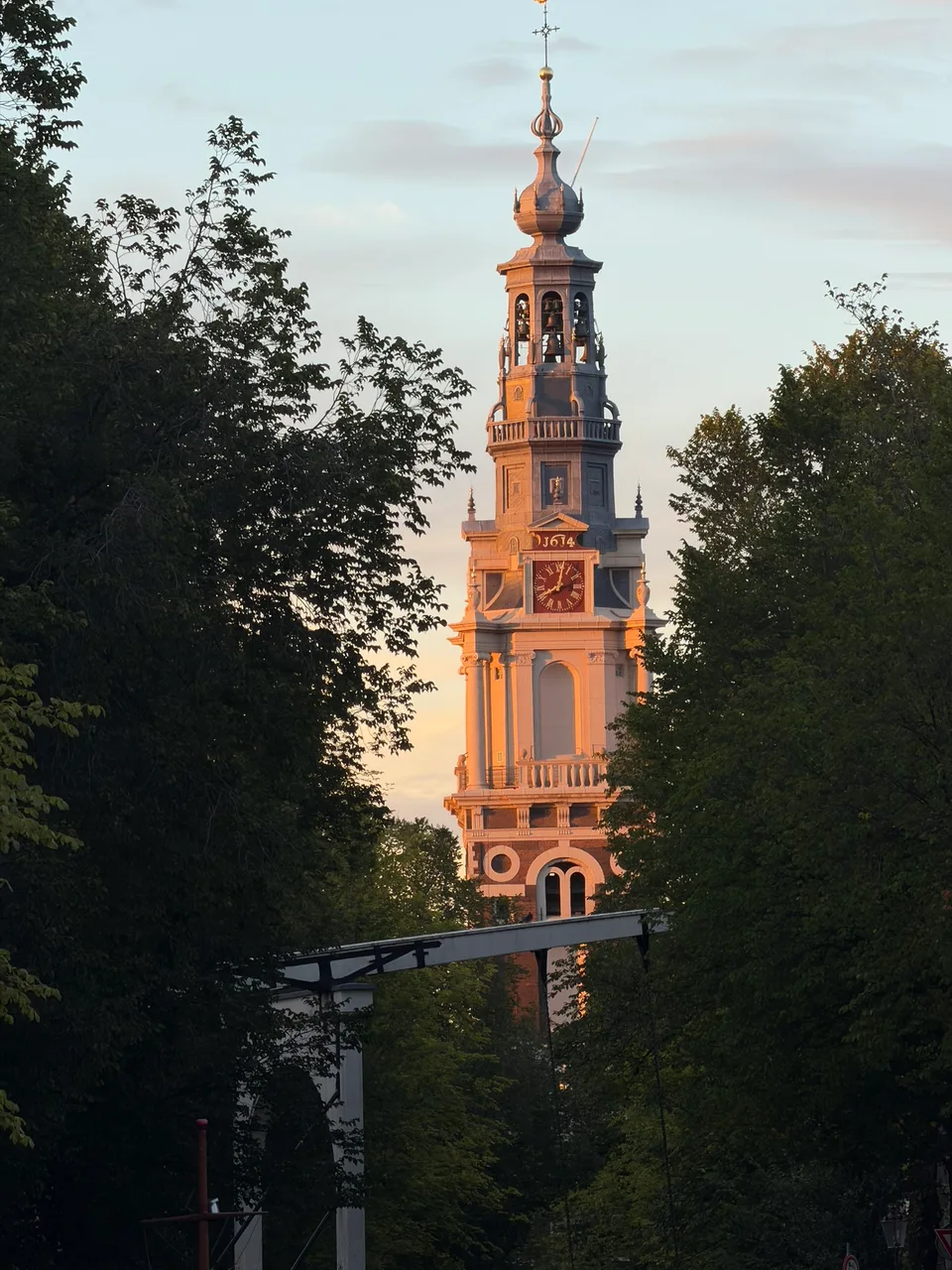 A torre da Westerkerk entre as árvores junto a um canal