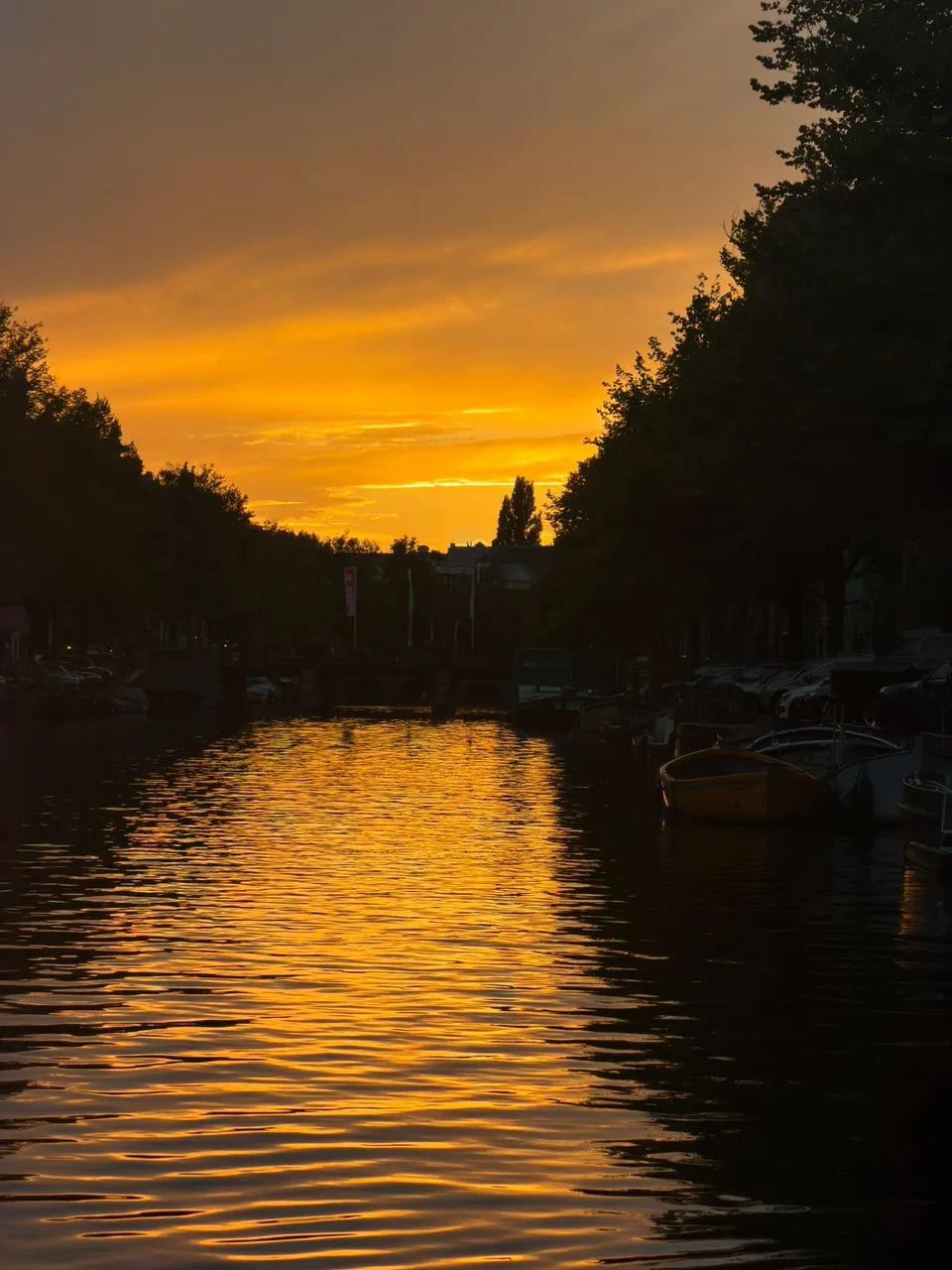 O pôr do sol alaranjado refletido em um canal de Amsterdã