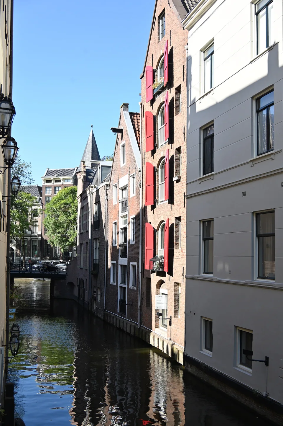Um canal estreito entre edifícios claros de Amsterdã