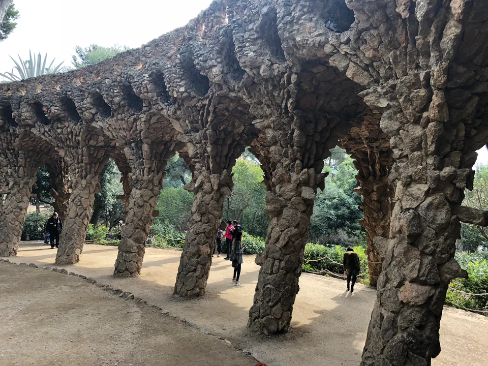 Leaning stone columns beneath a Park Güell viaduct