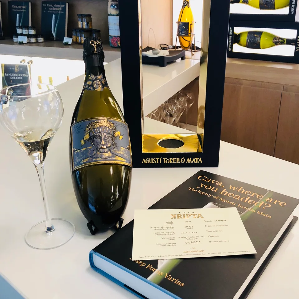 A Kripta cava bottle, tasting glass and Cava, where are you headed? book