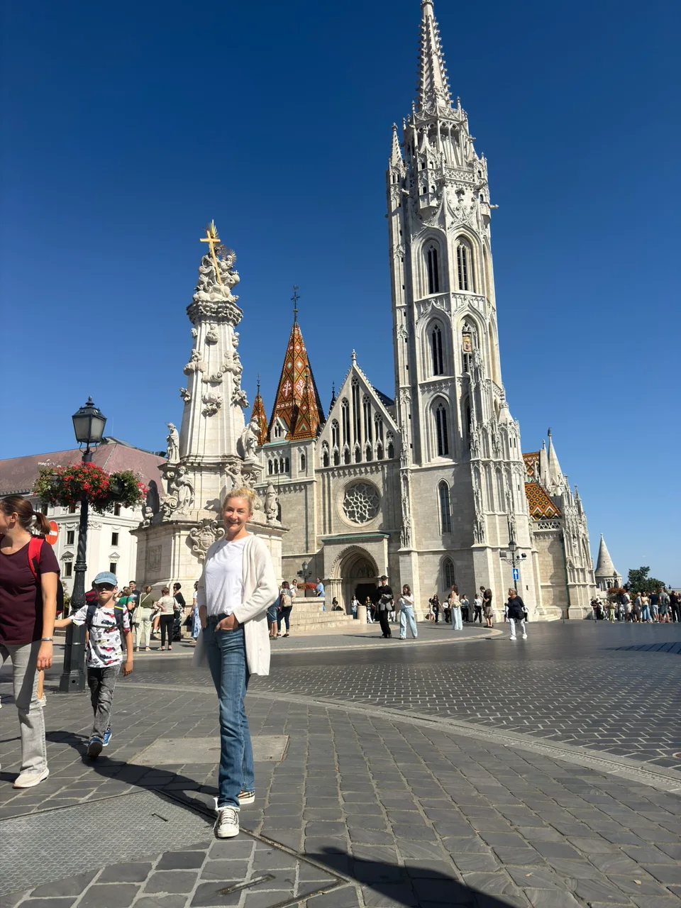 A torre branca e o telhado estampado da Igreja de Matias com Kristin em primeiro plano
