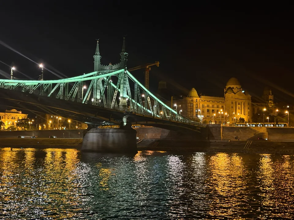 A Ponte da Liberdade iluminada em verde junto aos edifícios da margem