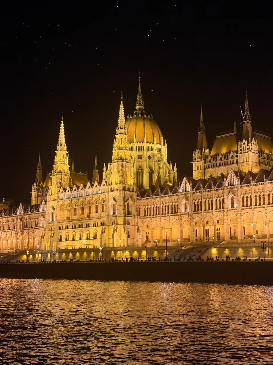 A cúpula e as torres iluminadas do Parlamento húngaro à noite