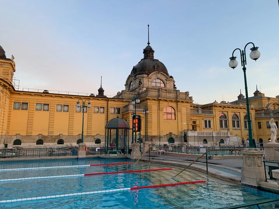 Uma piscina externa entre edifícios amarelos nas Termas Széchenyi