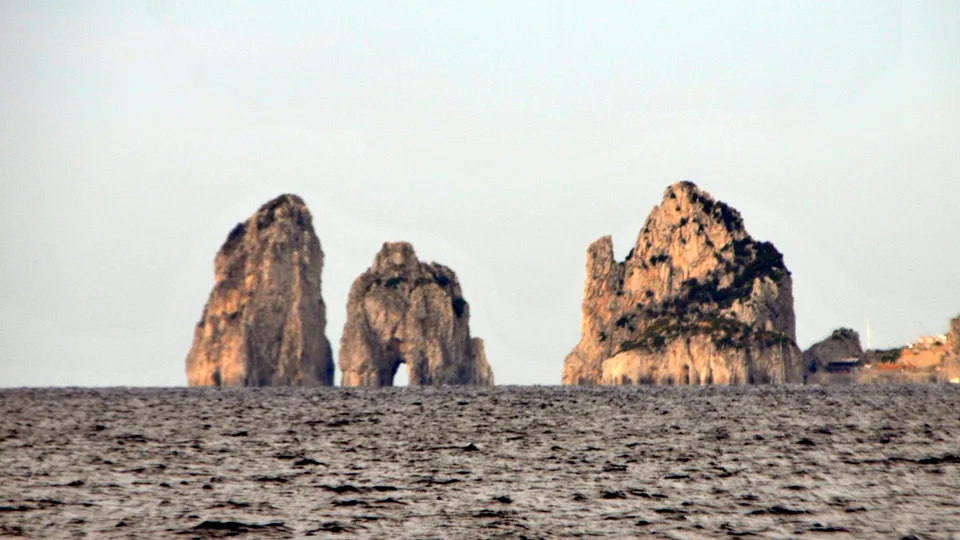 Capri’s Faraglioni sea stacks catching warm light above rippled water