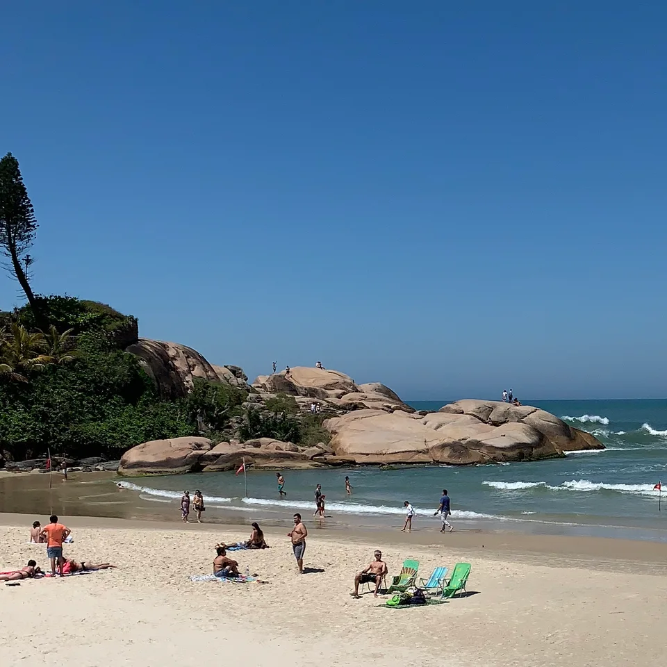 Beachgoers near large rounded rocks at Joaquina