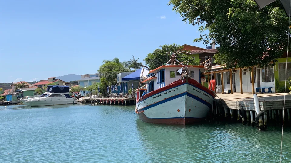 A painted fishing boat moored alongside waterfront houses