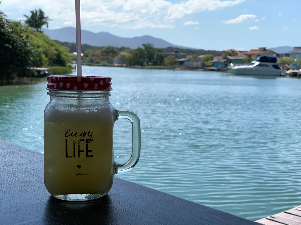 A drink in a glass jar on a table beside the channel