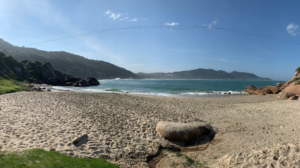 A sandy beach between wooded headlands on Florianópolis’s eastern shore