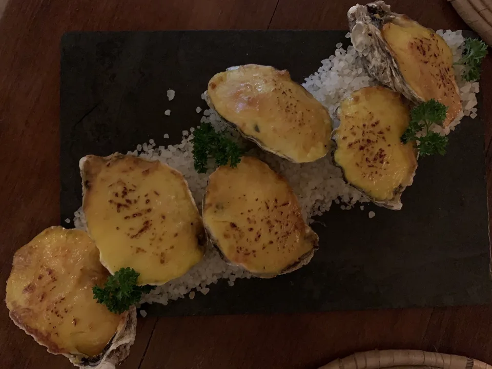 A small plated dish with golden toppings at a restaurant table