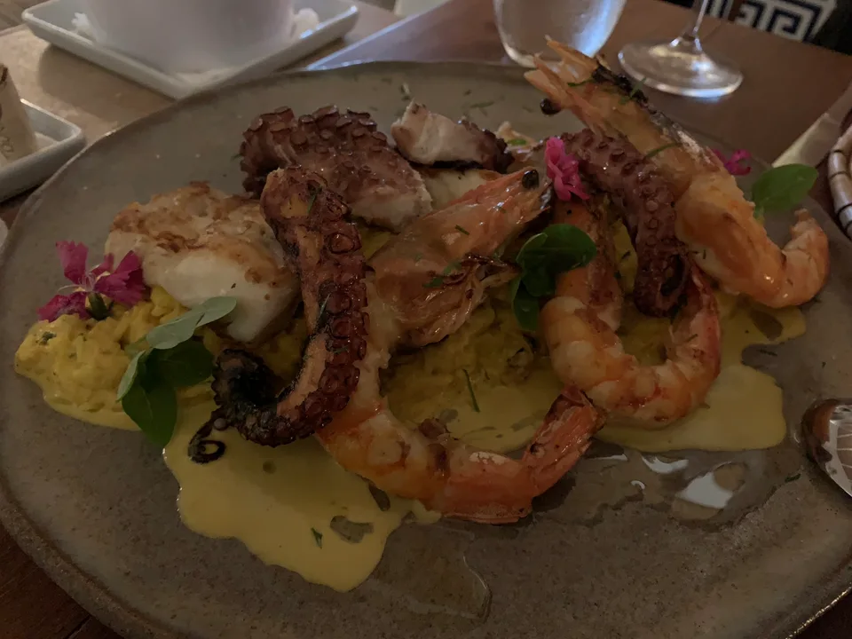 A large seafood dish with prawns and garnishes on a dining table