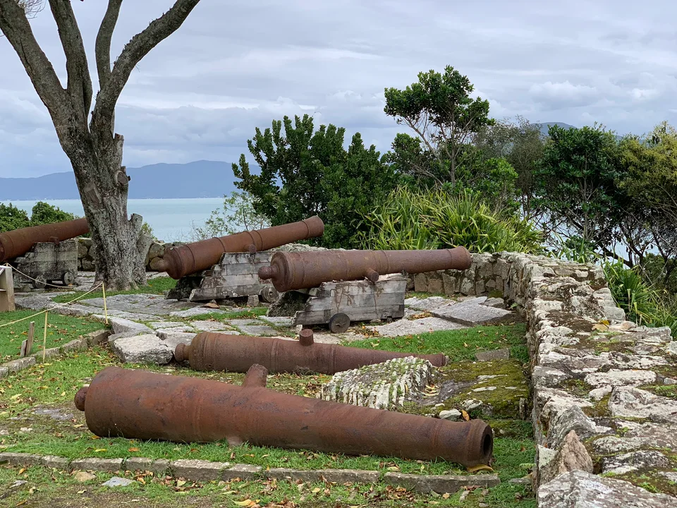 Old iron cannons aimed across the water from the fortress grounds