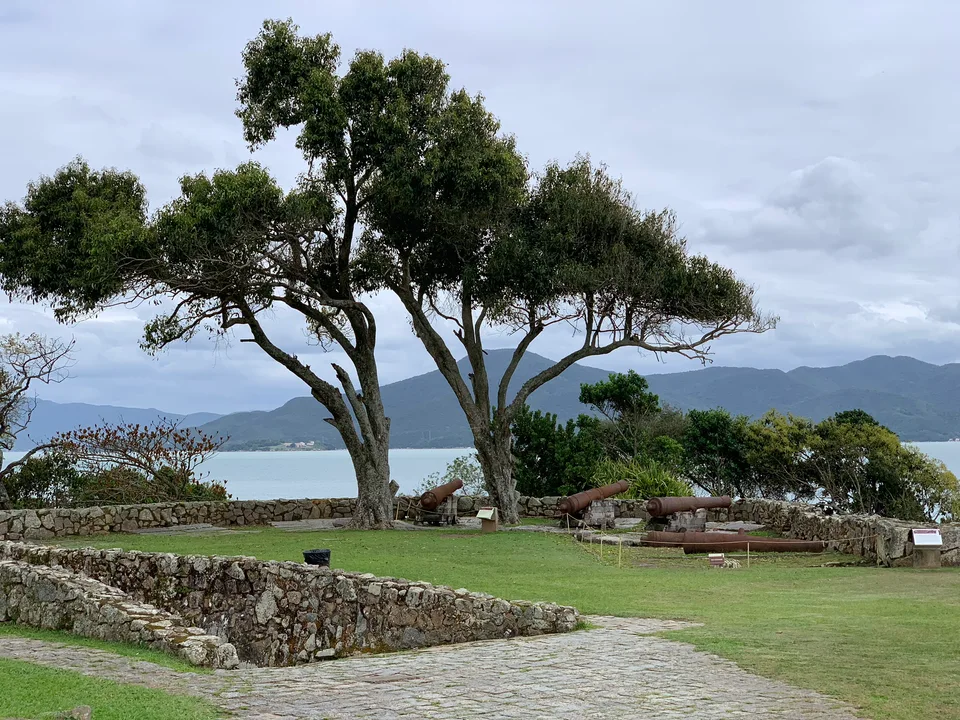 Trees and low stone walls overlooking the bay at Ponta Grossa