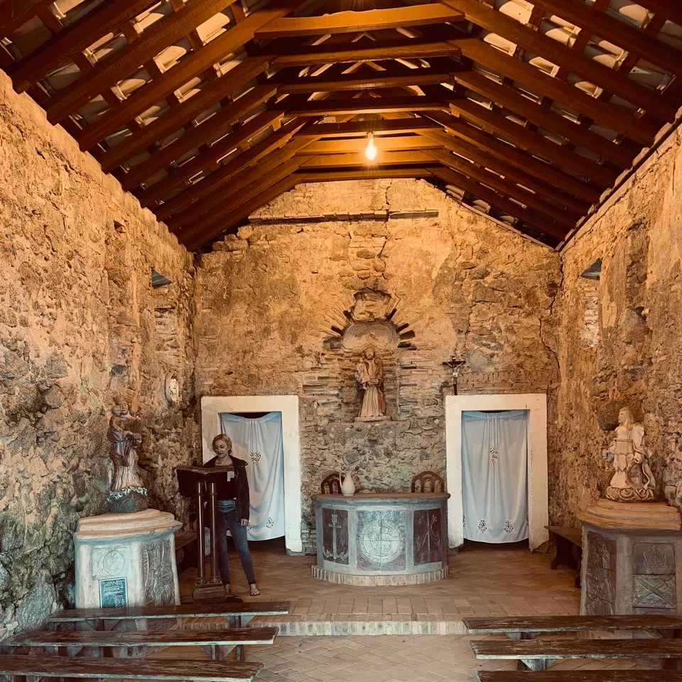 A modest altar beneath the timber roof of the fortress chapel