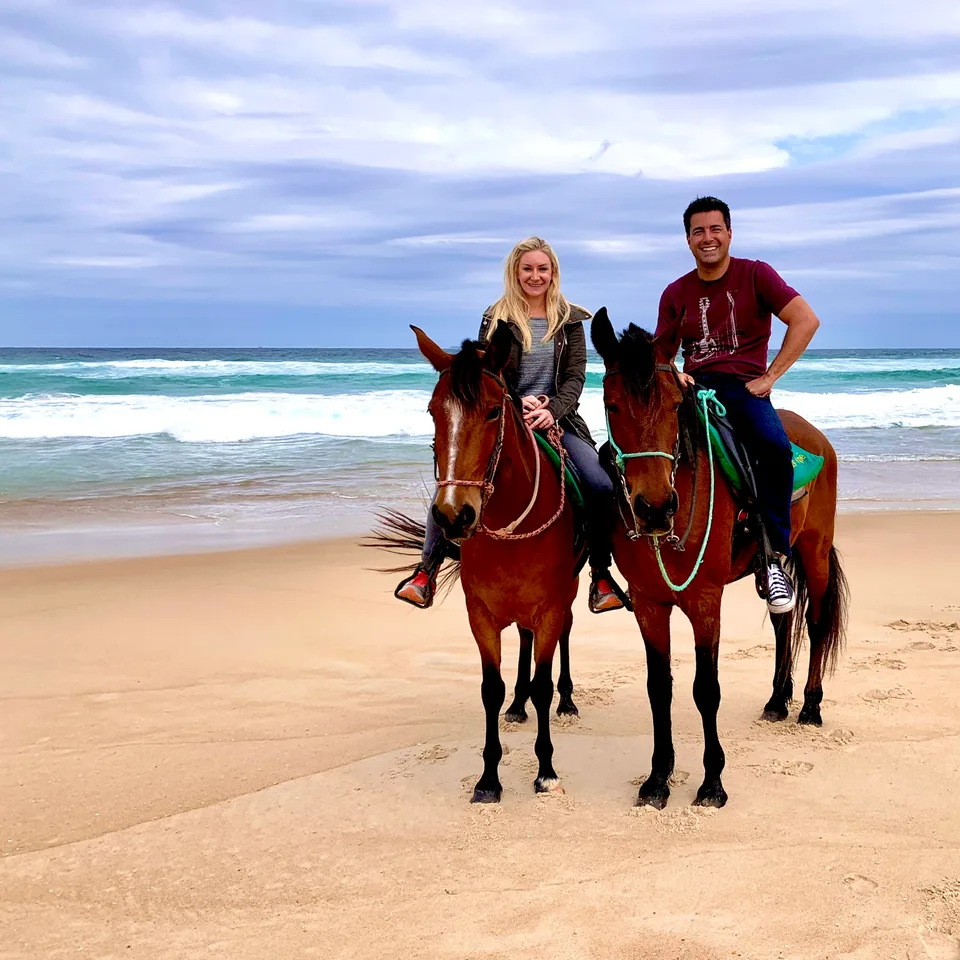 Alex and Kristin on horseback beside breaking waves on Moçambique beach