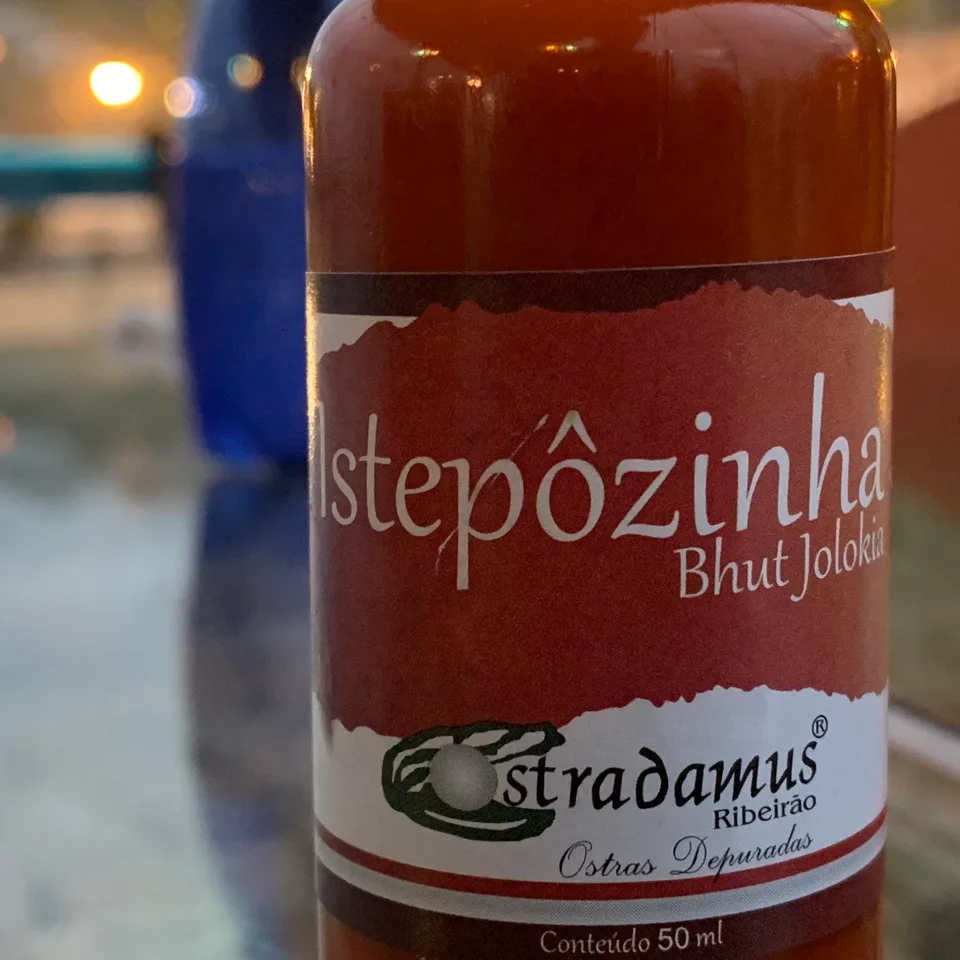 A bottle labeled Ostradamus Estepôzinha on a restaurant table