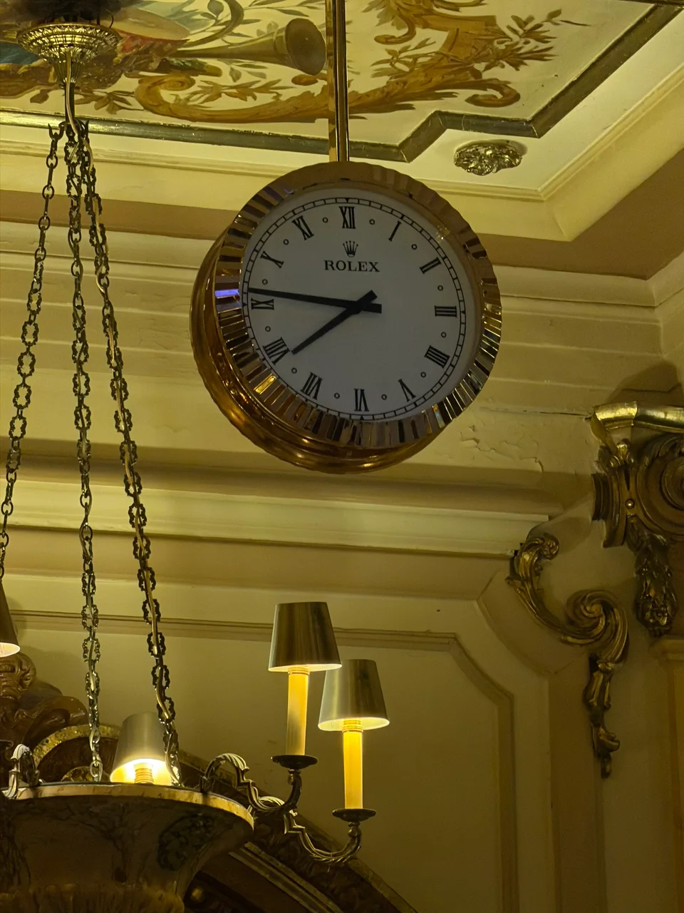 A large clock suspended inside the Yacht Club de Monaco