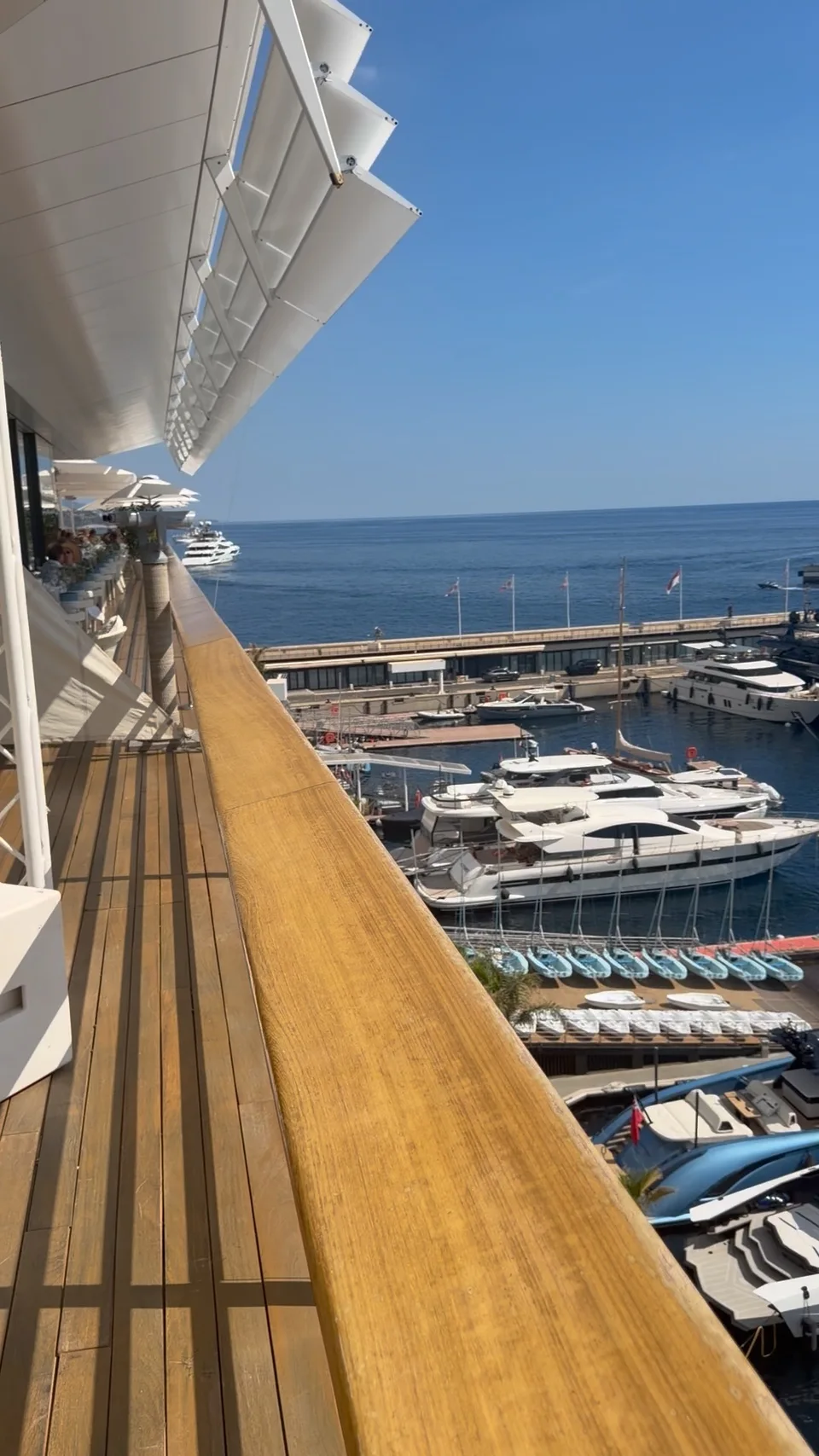 A long wooden terrace overlooking Monaco’s harbor