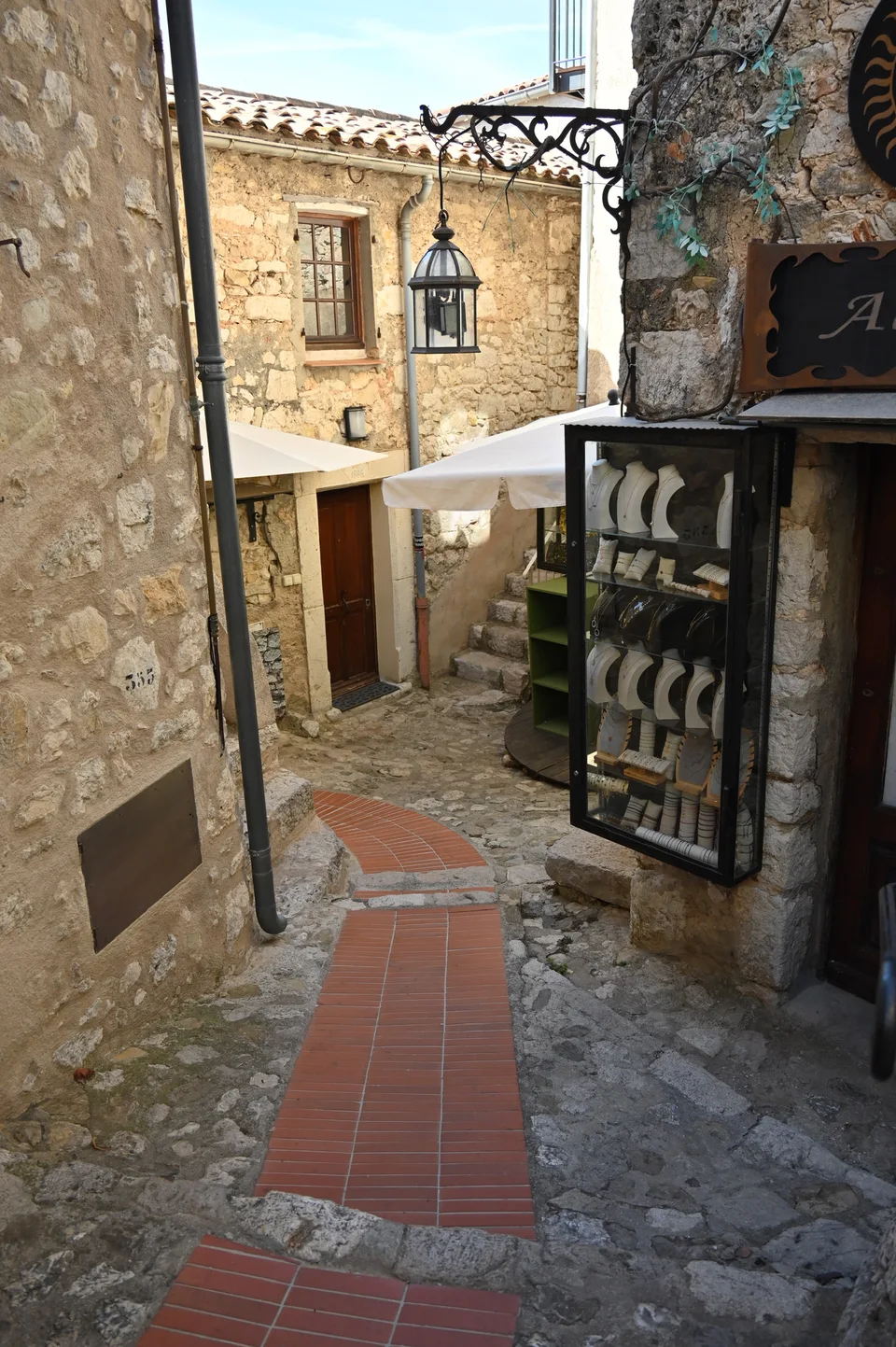 A stone passage beside a small restaurant terrace in Èze