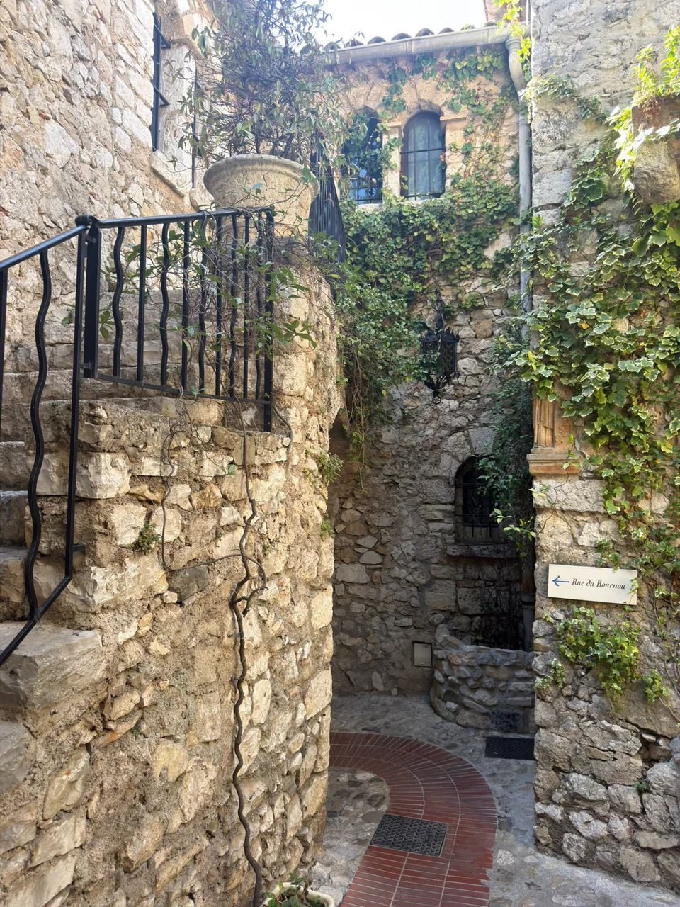An arched doorway and greenery along an Èze lane
