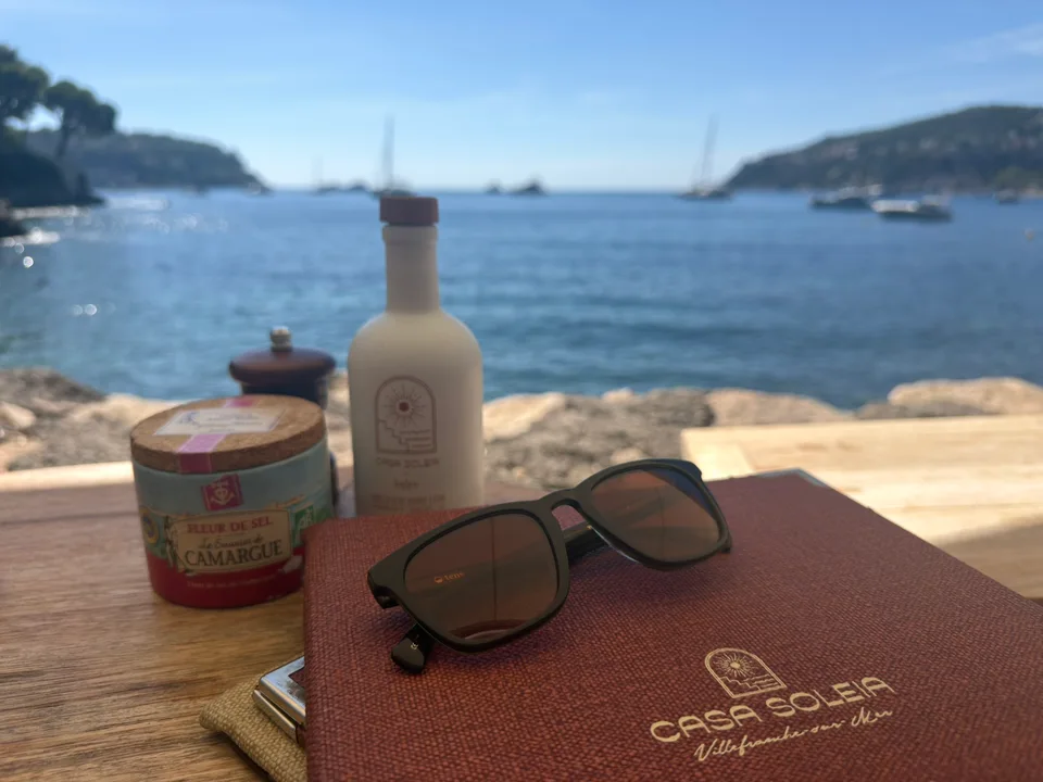 Sunglasses and a menu on a table overlooking Villefranche bay