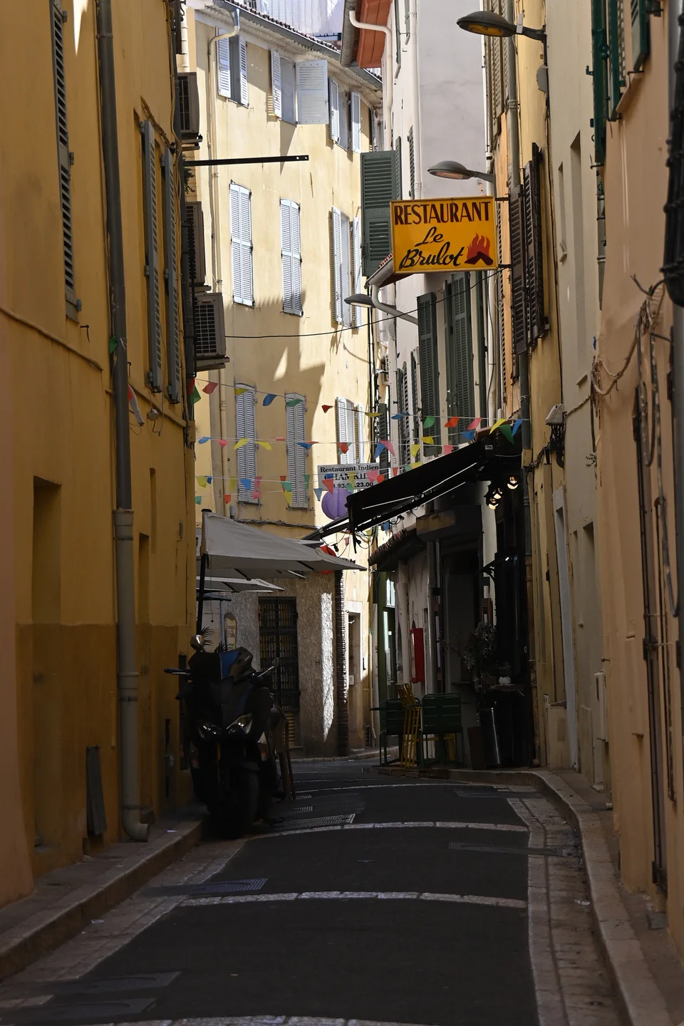 A quiet narrow street lined with yellow and peach façades