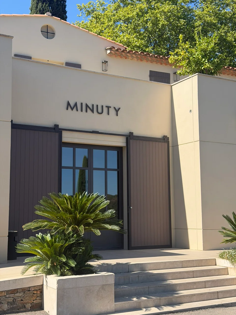 The entrance to Château Minuty beneath a white sign