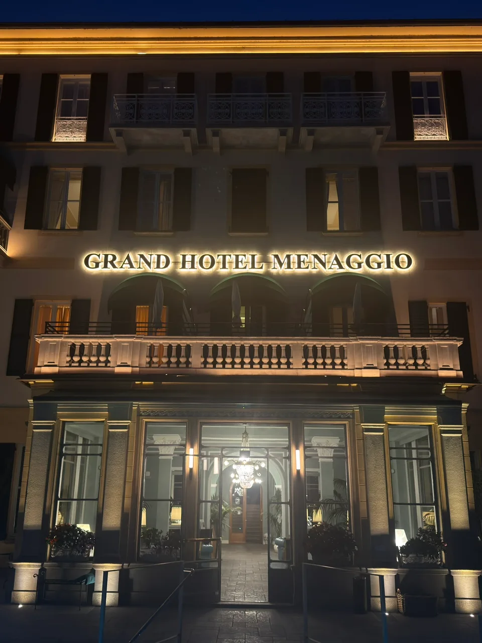 A fachada iluminada do Grand Hotel Villa Serbelloni à noite