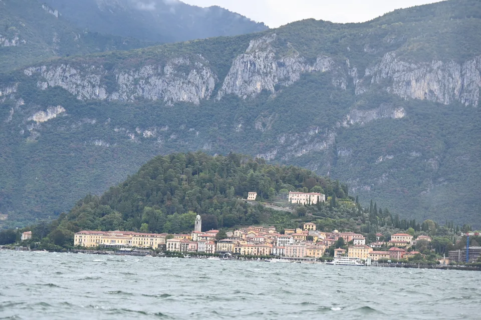 Uma vila ao pé de montanhas íngremes do outro lado do Lago de Como