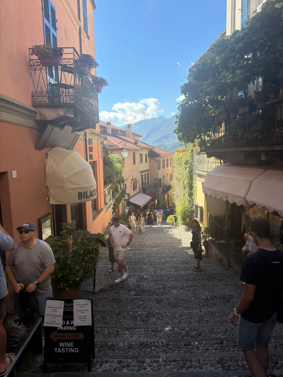 Uma rua estreita com escadas e lojas em Bellagio