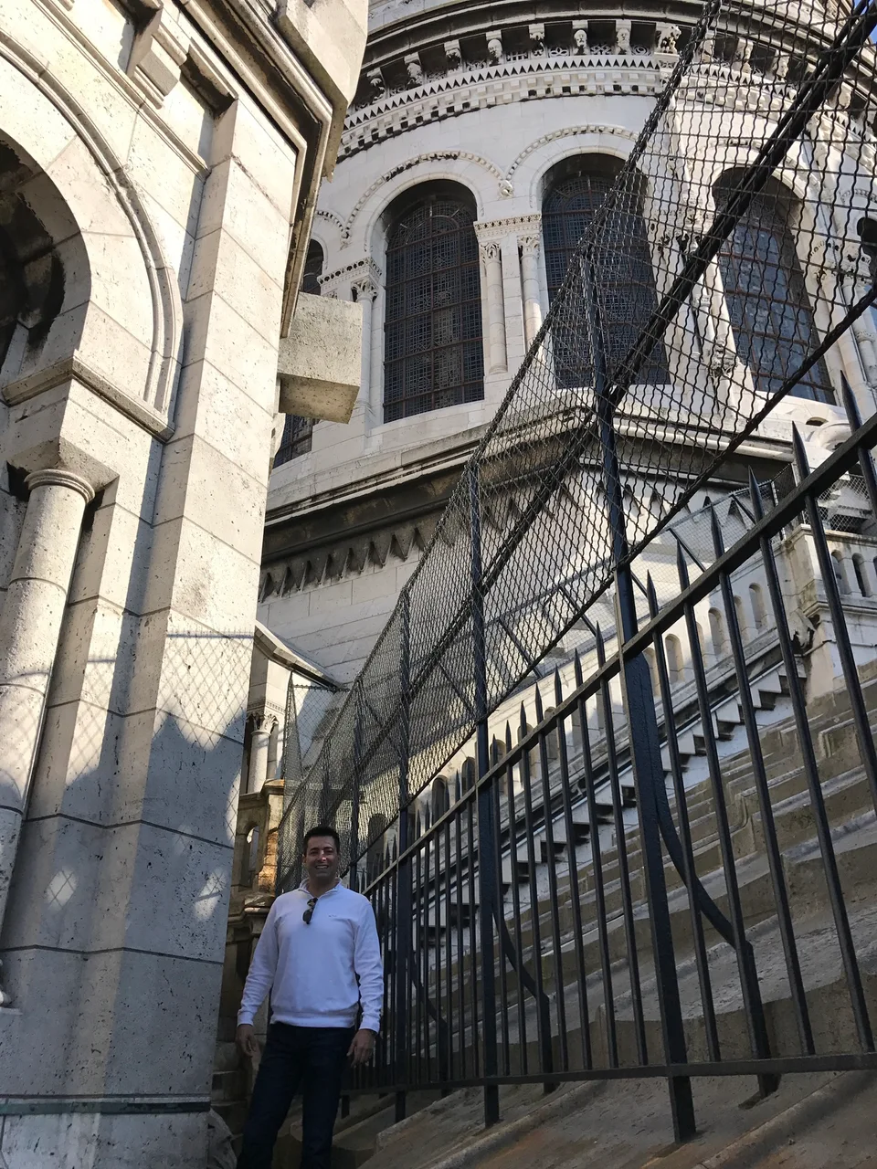 Arcos de pedra, uma porta esculpida e corrimãos de ferro em Sacré-Cœur