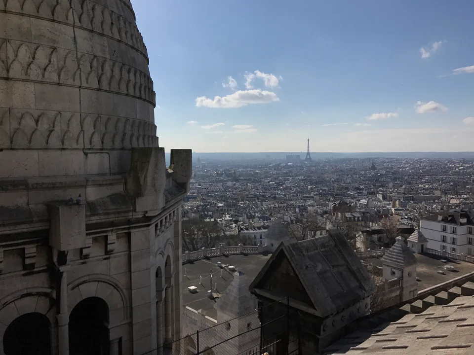 Telhados de Paris sob a curva de pedra de uma cúpula de Sacré-Cœur