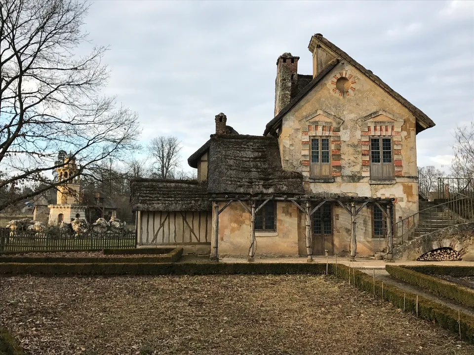 Uma casa rústica com paredes de pedra e telhado inclinado no Hameau da Rainha