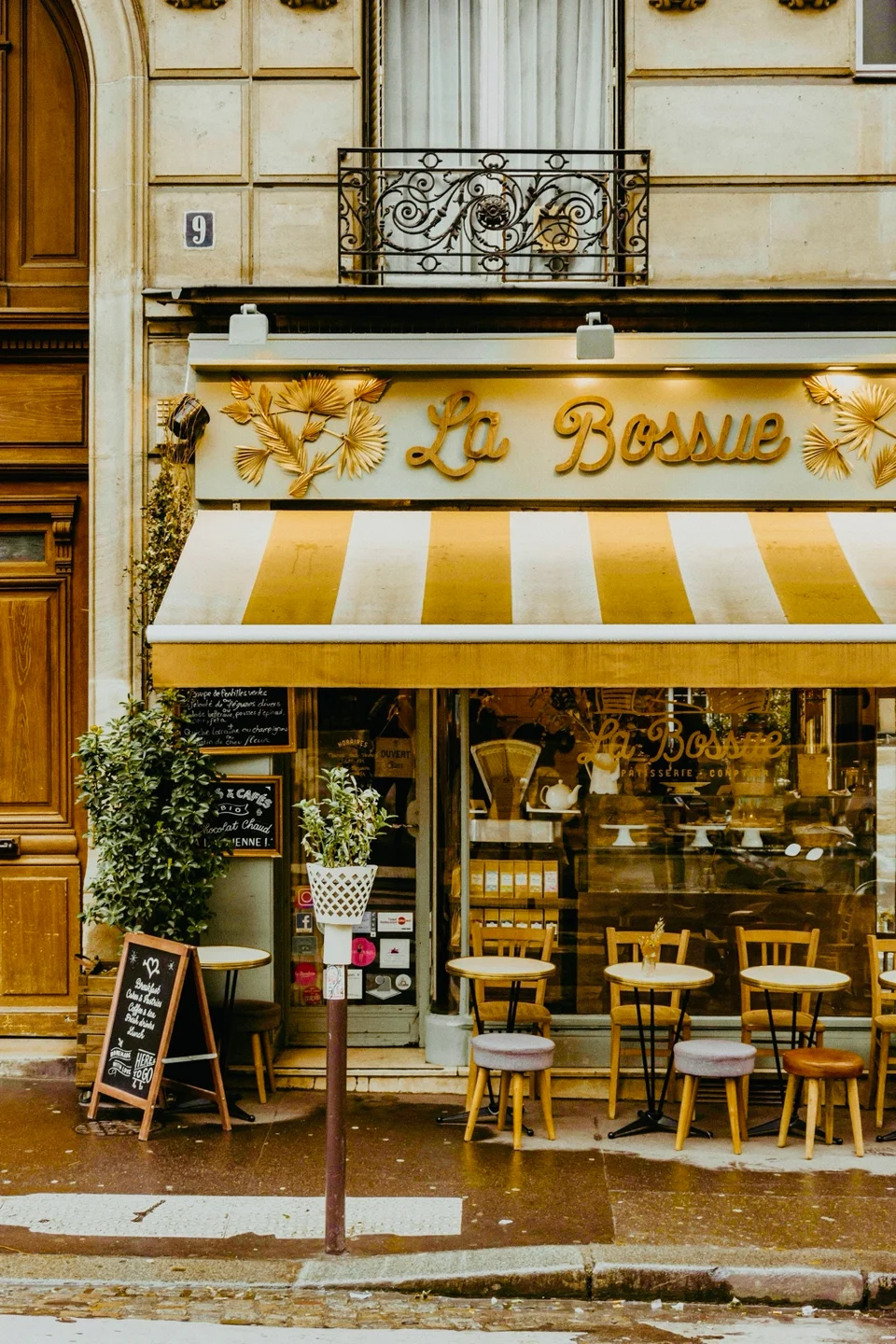 The yellow La Bossue café sign and striped awning above outdoor tables