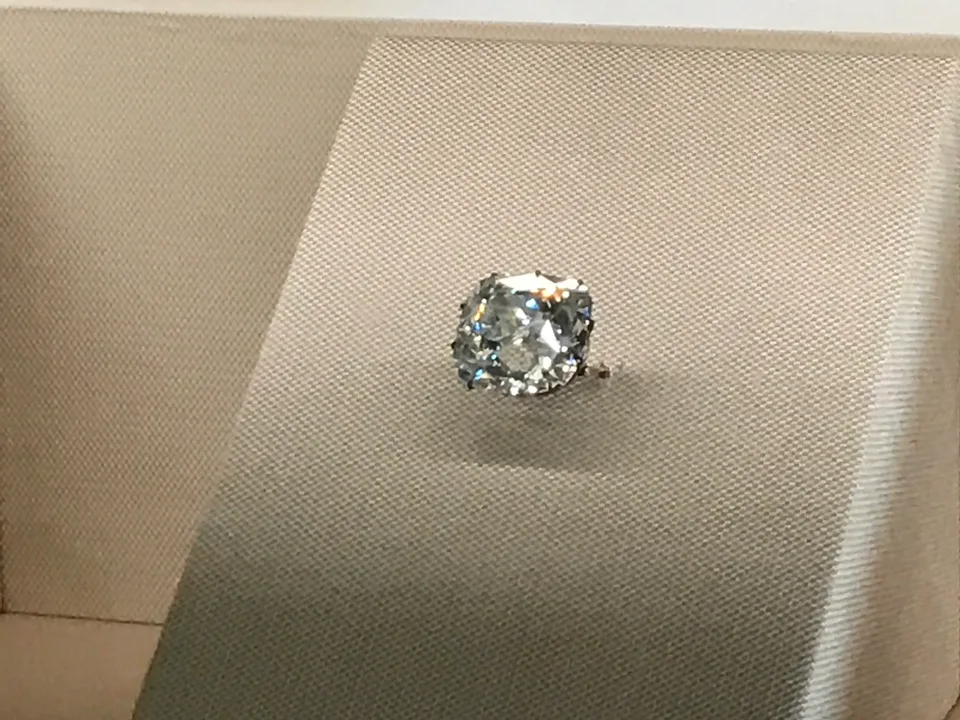Um grande diamante lapidado num pequeno pedestal claro no Louvre