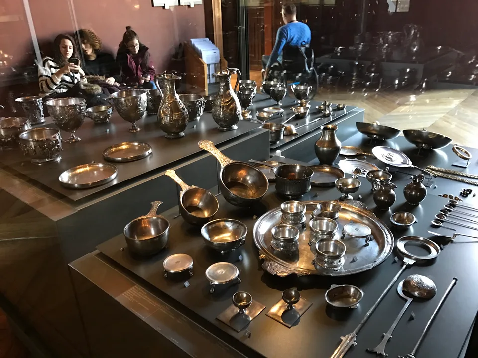 Um serviço de mesa de prata elaborado sobre uma mesa de exposição no Louvre
