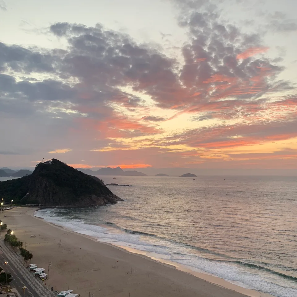 Pink and orange clouds above the sea and Rio’s coastal hills