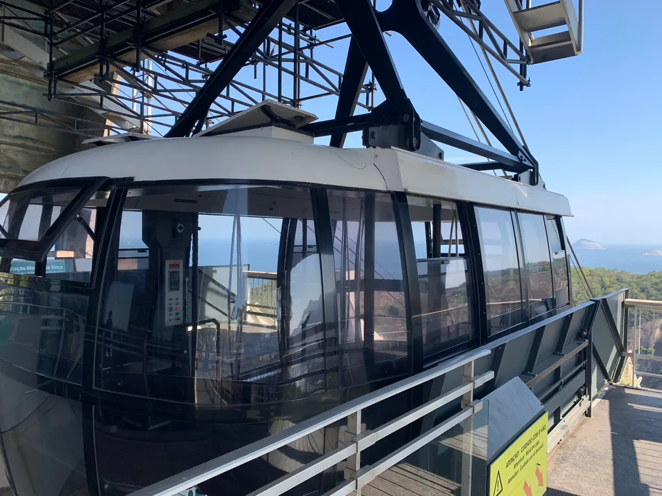A glass Sugarloaf cable car beneath the station’s steel structure