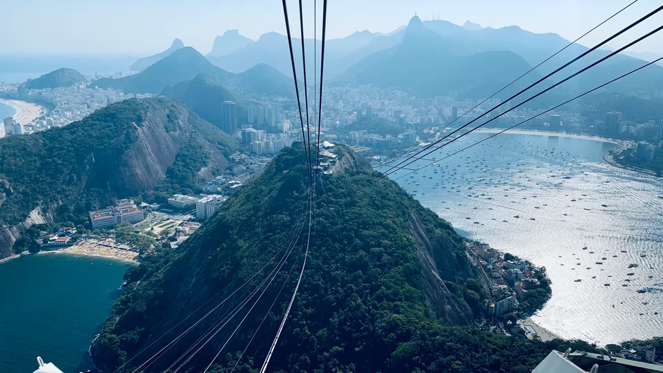 Cable lines converging toward Morro da Urca above Rio’s bay and buildings