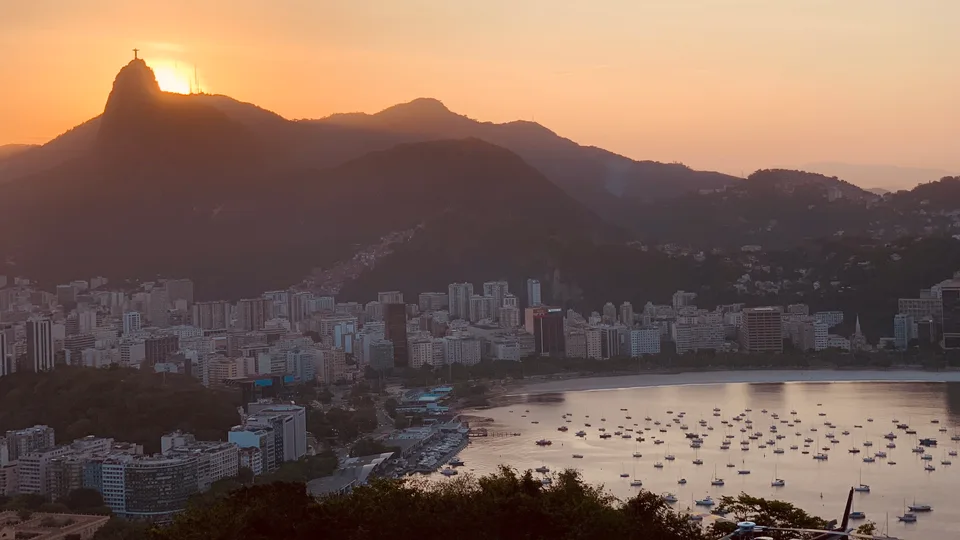 An orange sunset above Rio’s mountain silhouettes and coastline