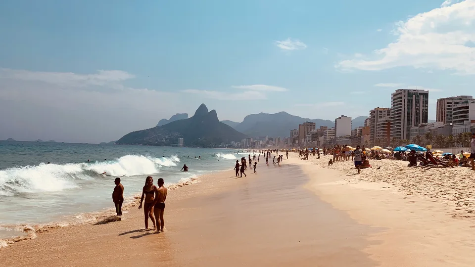 Waves rolling onto Ipanema beach with Dois Irmãos in the distance