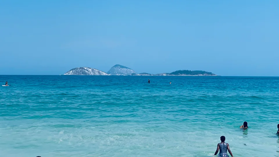Turquoise Atlantic water with offshore islands and beachgoers below