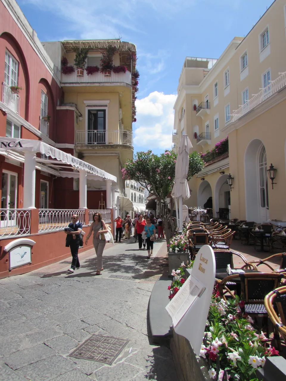 Butiques, toldos e pedestres na Via Camerelle em Capri