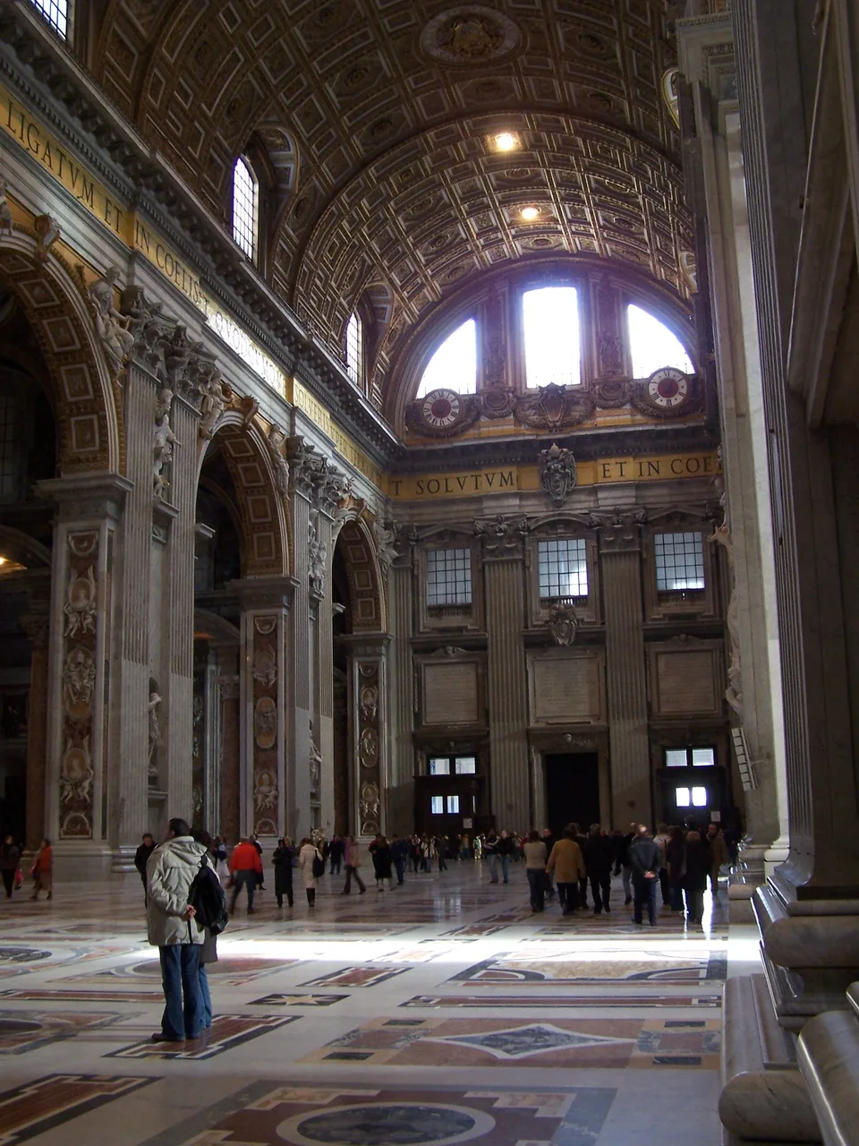 Luz do sol no piso de mármore sob as abóbadas decoradas da Basílica de São Pedro